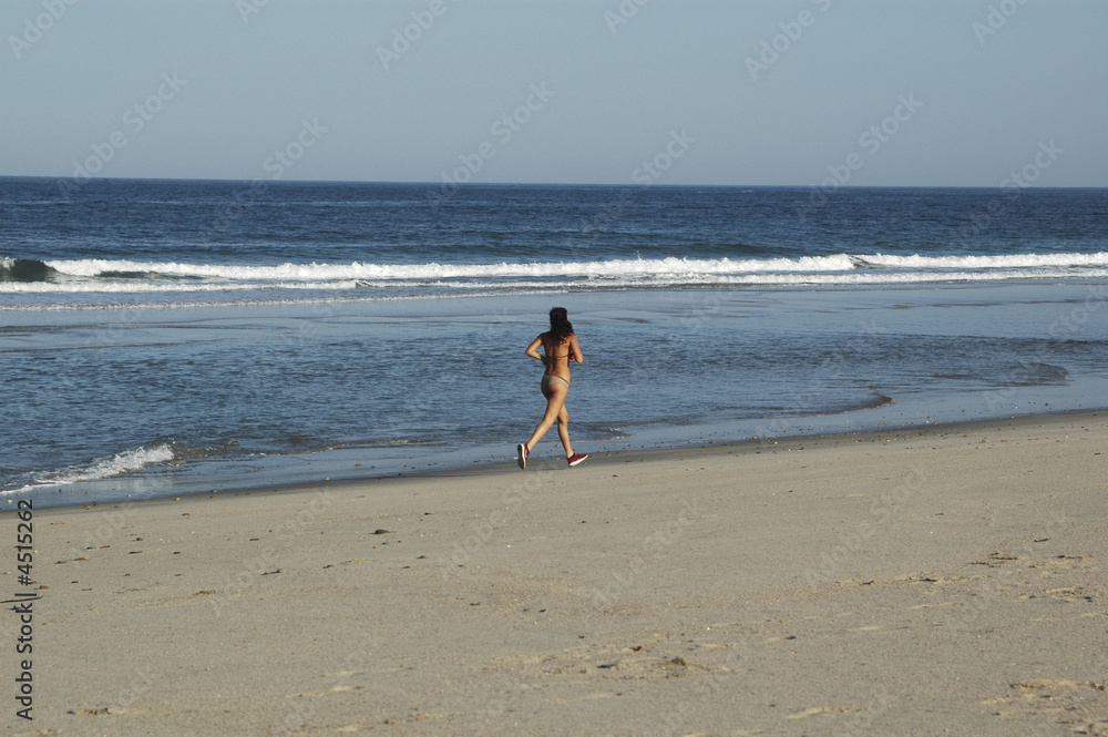 a young woman runs for the together beach to the sea ll... a young woman runs for the together beach to the sea ll...