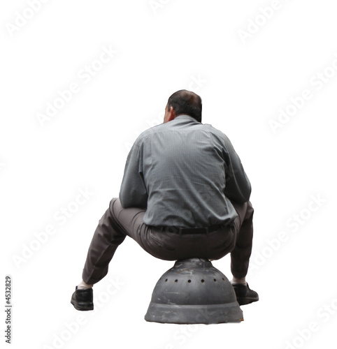 Rear view of a man sitting on a metal structure, isolated