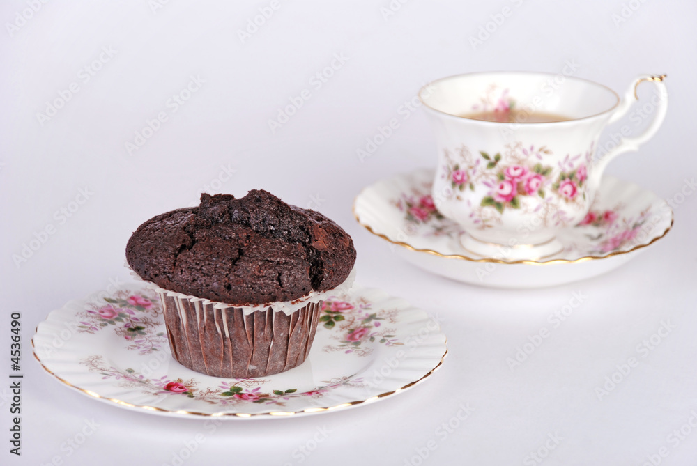 Cup of tea & chocolate muffin - focus on muffin