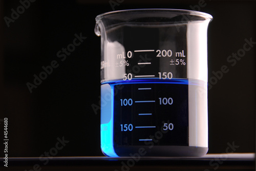 Beaker with blue liquid, black background