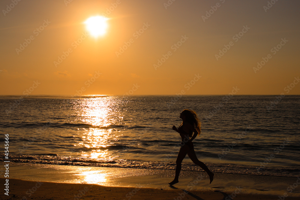 Female running along the beach at sunrise