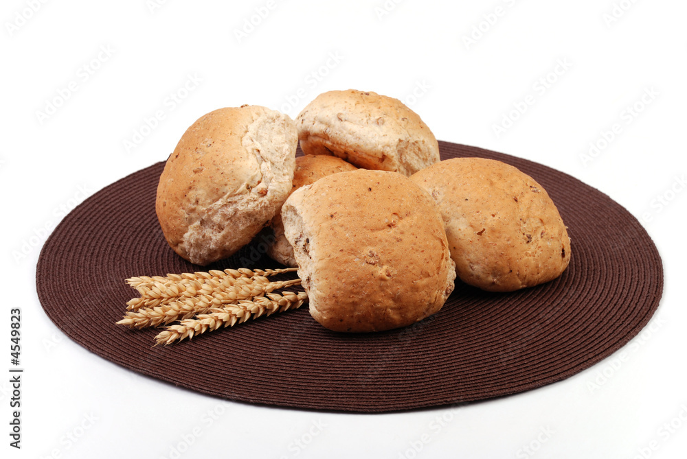 Granary bread rolls with wheat in the foreground Granary bread rolls with wheat in the foreground