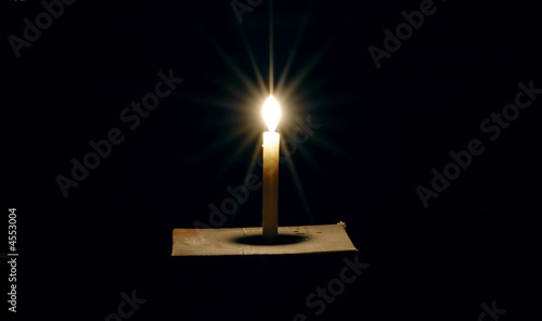 Burning candle on a black background  photo
