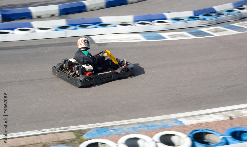Gokart going fast on open-air circuit.