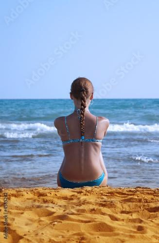 The lonely girl sits on seacoast