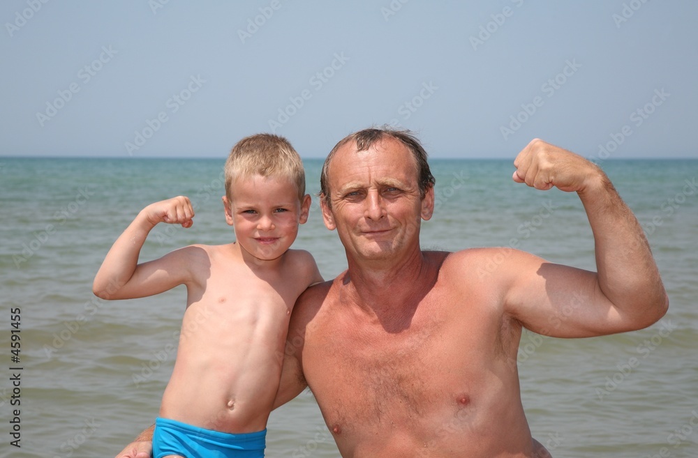 Grandfather and grandson show bicepses Grandfather and grandson show bicepses