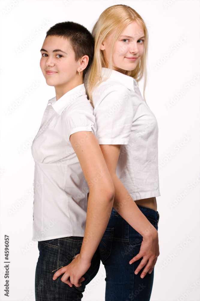Blond and brunette stands back to back Blond and brunette stands back to back
