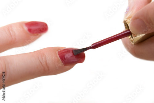 Painting acrylic finger nails with red varnish