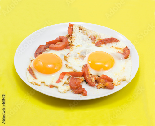 fried eggs with tomatos on yellow