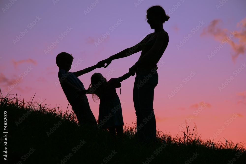 mother and children holds for hands on sunset mother and children holds for hands on sunset