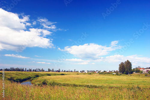 Canicular, sun day. River through the field.