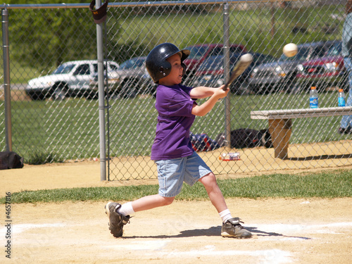 young baseball player hitting baseball 