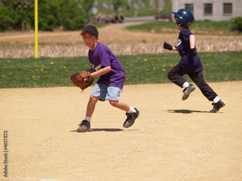 фотографія young baseball player as shortstop with runner behind