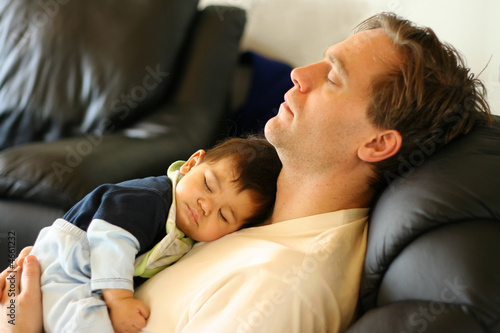 Принти на полотні Father sleeping on chair with his baby boy on chest