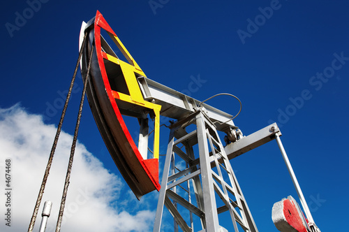 Oil pump jack against blue sky background