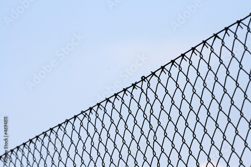 Chainlink fence against blue background