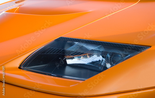 Headlamp on bright orange supercar photo