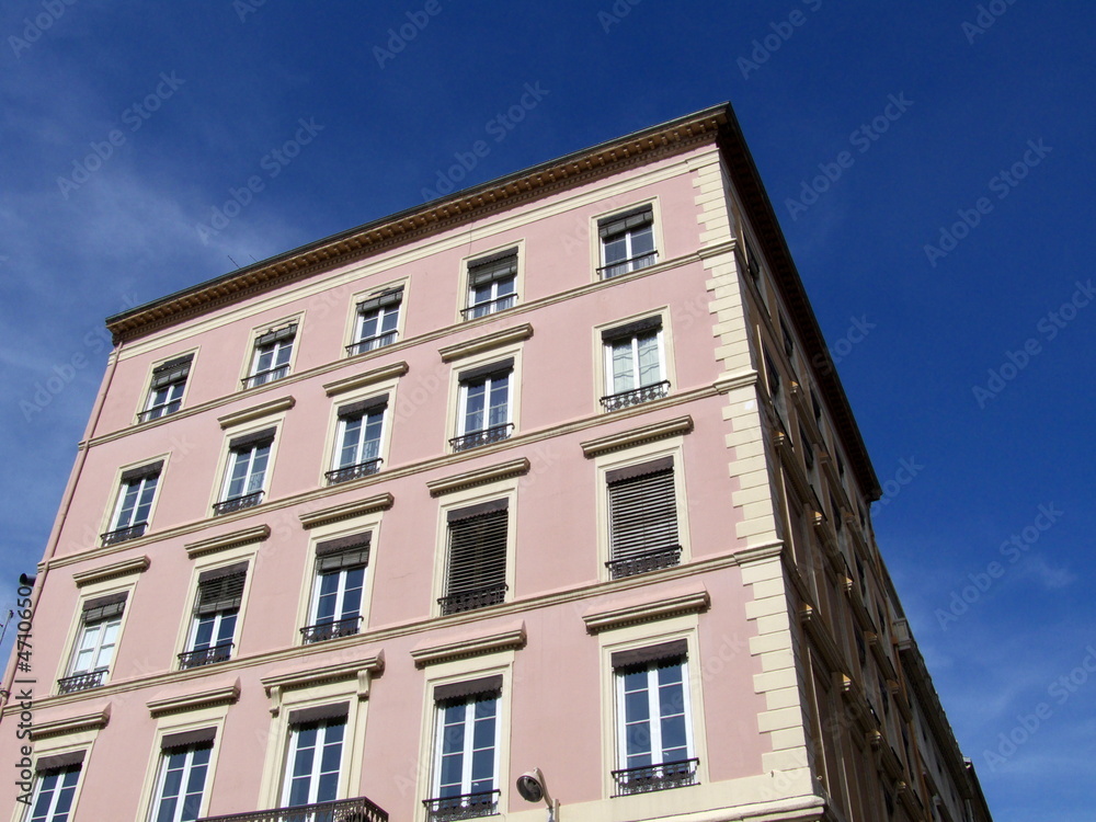 Immeuble rose et crème, Ciel bleu. Lyon. France.