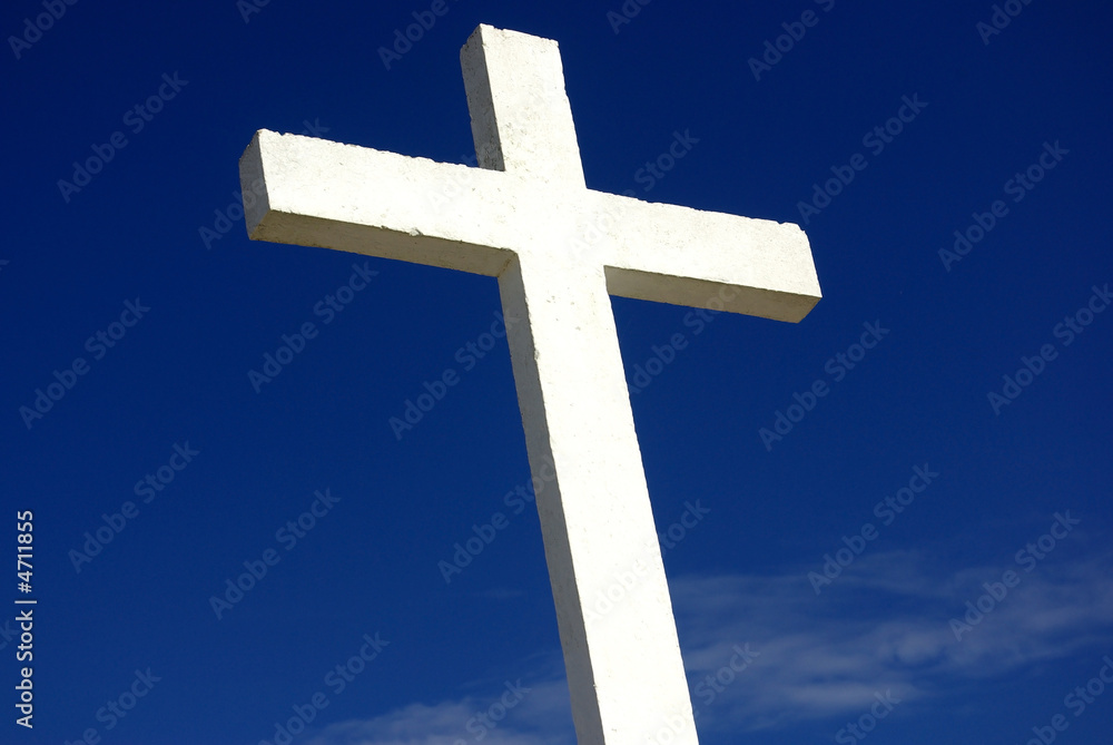 white cross and church against blue sky