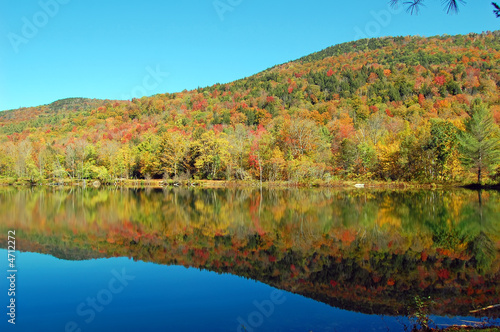 Mountains and trees reflect in a pond in Vermont.