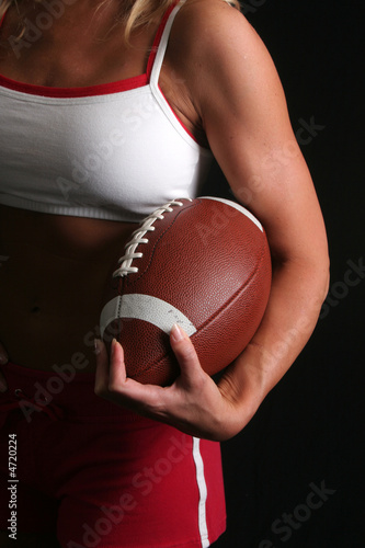 Shapely woman holding a football