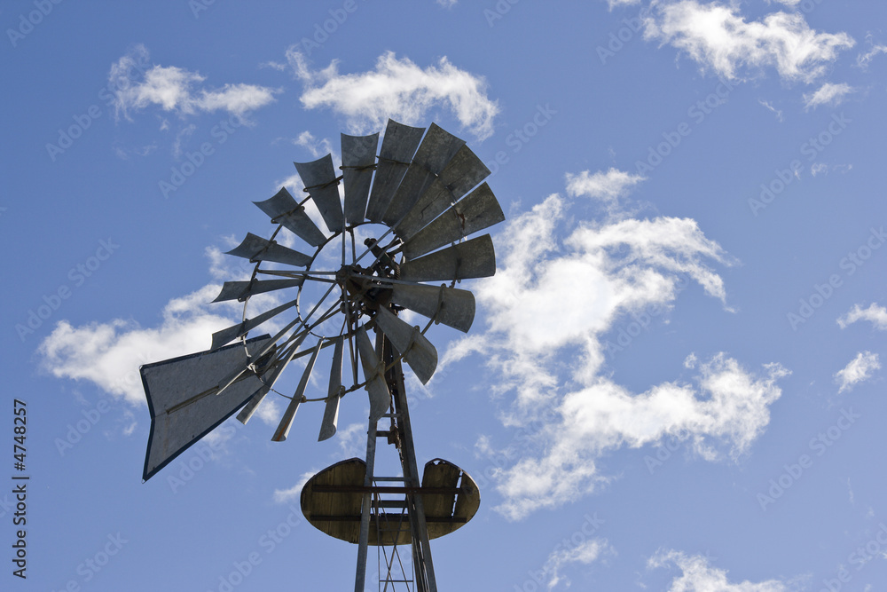 Antique windmill against clouds