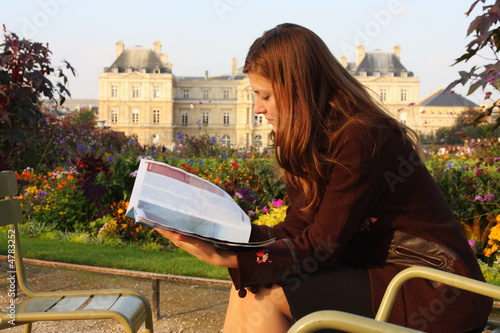 Pretty girl reading magazine in Luxembourg garden