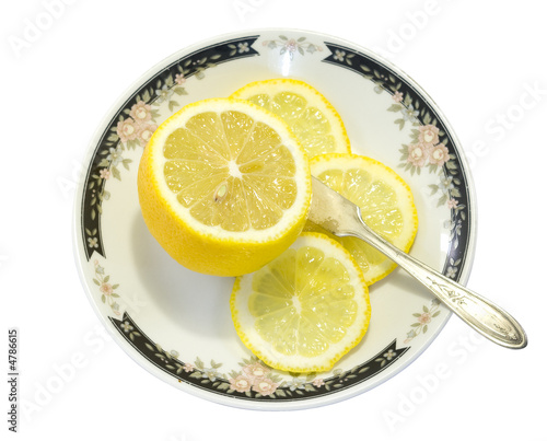 Sliced Lemon and knife on a plate isolated on white background