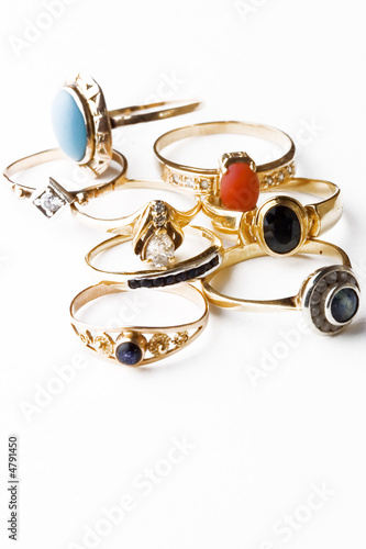 Golden rings with precious stones isolated on white
