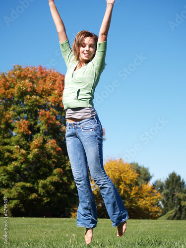 teenage girl jumping in air on autumn day