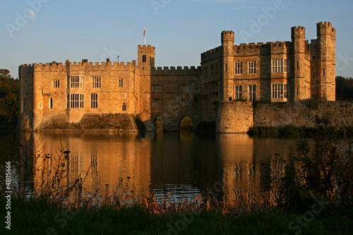 the sun doing down on leeds castle with moon in the sky