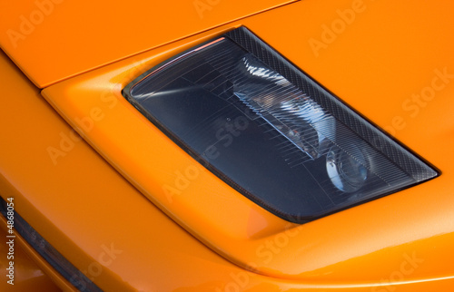 Headlamp on a vivid orange Italian super car photo