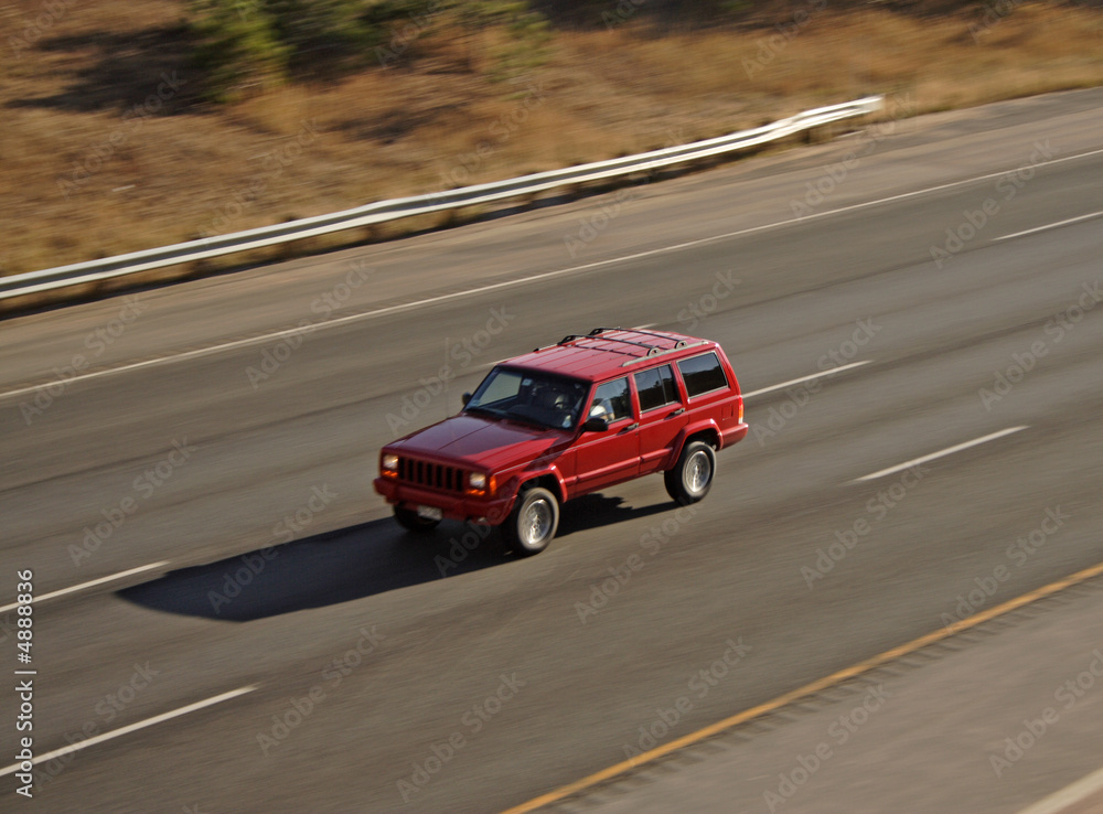 Panning Red vehicle on highway