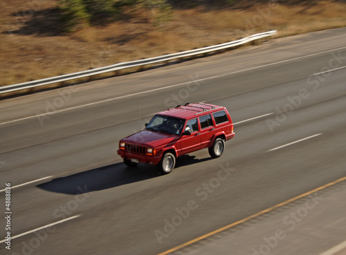 Panning Red vehicle on highway