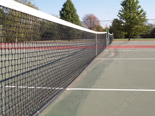 net on a tennis court with view from side of the court