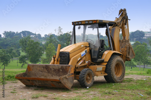 orange power shovel parked on an open field