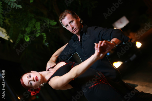 Couple dancing on a street at night.