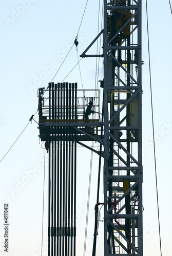 Fototapeta Roughneck pushes pipe from drilling rig pipe rack