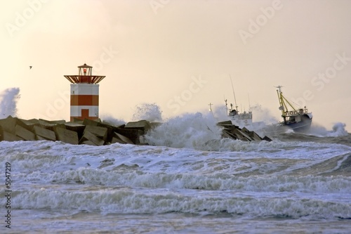 Fotografia Fishingboat near lighthouse at a storm in Holland