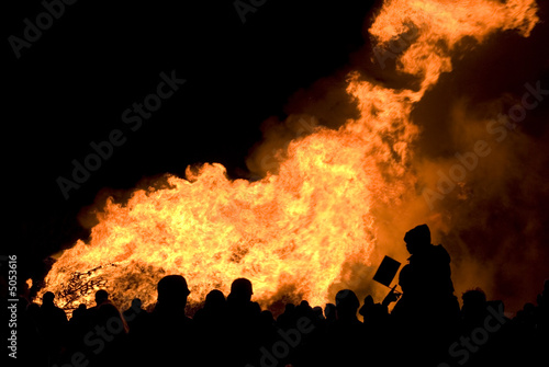 Silhouette of crowd against large bonfire on bonfire night