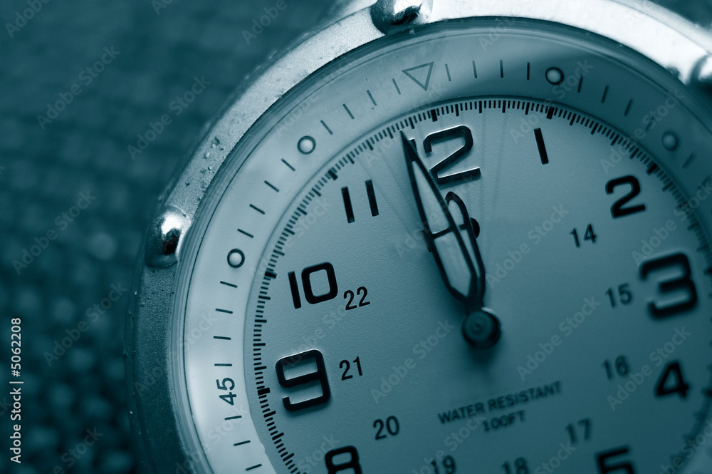 Closeup of a watch with both hands near 12 Closeup of a watch with both hands near 12