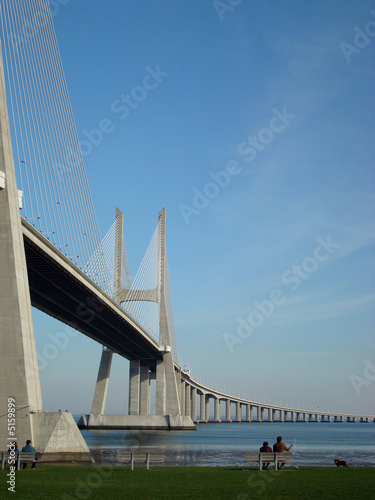 Casal a conversar junto ao rio - ponte Vasco da Gama em Lisboa