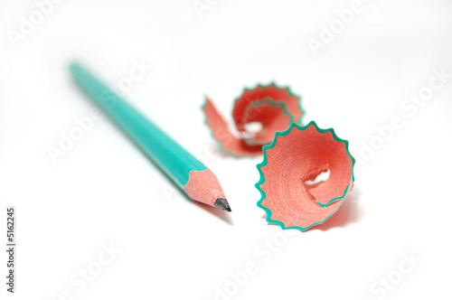 green pencil with cuttings in curve shape isolated on white