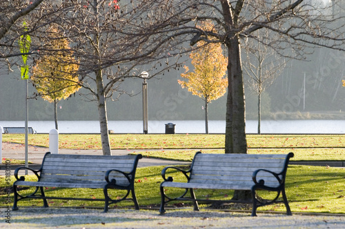 Two wooden chairs in a city park in autumn © jc