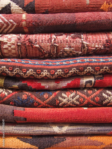 Red turkish carpets stacked in a traditional store