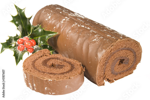 Sliced Christmas yule log with decoration on white background