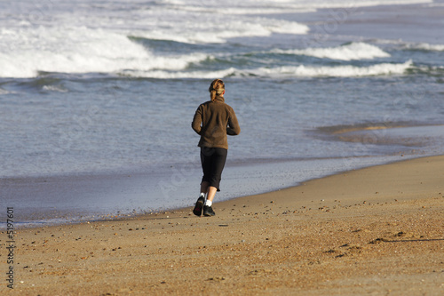 femme entrain de courir sur la plage photo