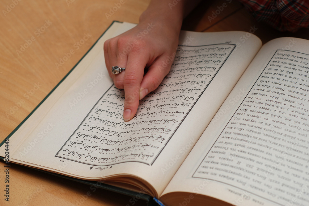 Obraz premium Close up of girl's finger on Quran