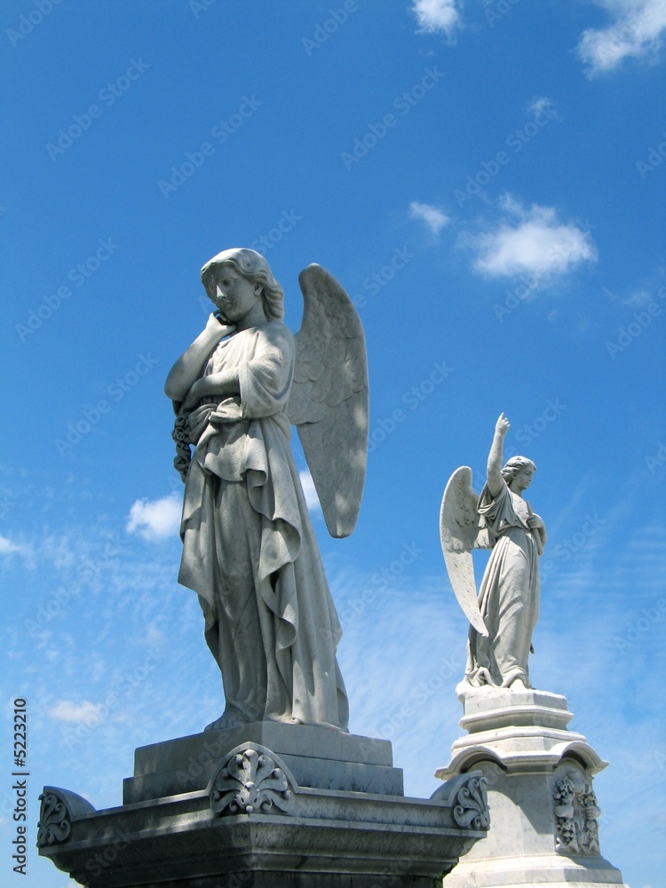 Fototapeta premium Detail of winged angel statue against blue sky
