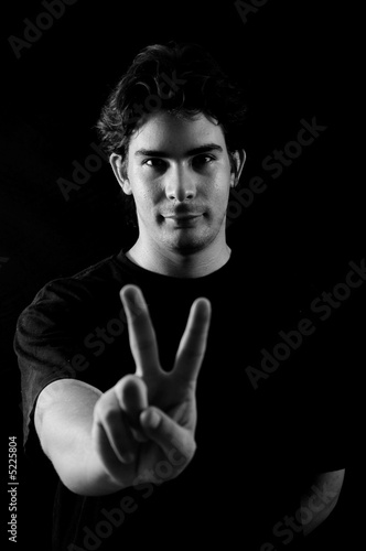 Young positive friendly man doing a sign with a hand 